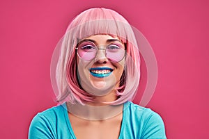 Young woman with pink hair and sunglasses have bright makeup isolated pink background