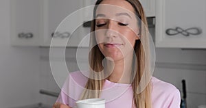 Young woman in pink t-thirt enjoy drinking tea with winter cookie at home