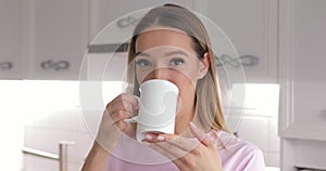 Young woman in pink t-thirt enjoy drinking tea with winter cookie at home