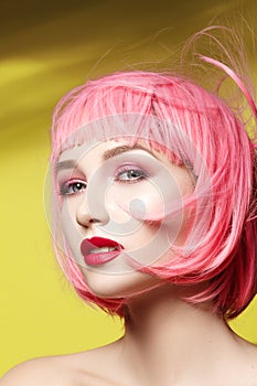 Young woman in pink wig. Beautiful model with fashion makeup. Bright spring look. hair color, medium hairstyle