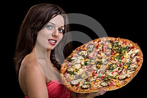 Young woman with pizza against black background