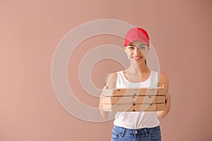 Young woman with pizza boxes on color background. Food delivery service