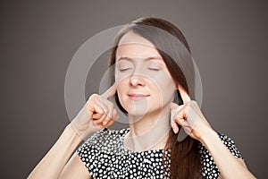 Young woman plagging up her ears