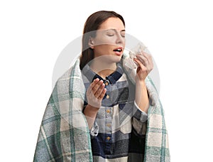 Young woman with plaid suffering from runny nose on white background