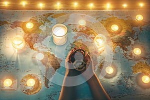 Young woman planning world tour with vintage travel map - Traveler girl using old compass with candles in background - Wanderlust