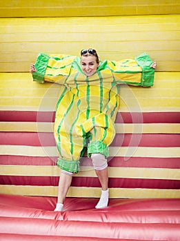 Young woman in plastic dress in a bouncy castle imitates a fly o