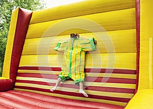 Young woman in plastic dress in a bouncy castle imitates a fly o photo