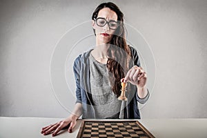 Young woman playin chess on her own