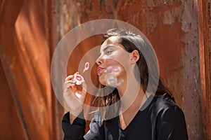 Young woman playing blowing soap bubbles