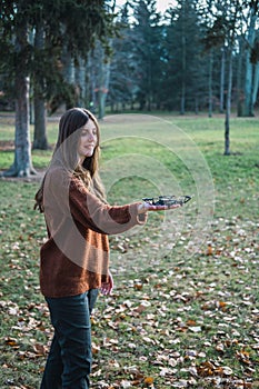 Young woman playing with a drone in a park