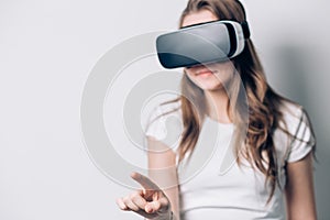 Young woman playing game in virtual reality glasses, VR headset glasses device.