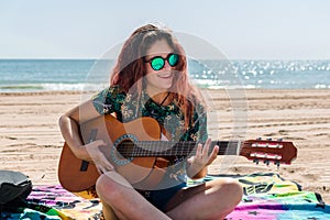 Young woman playing guitar on the beach