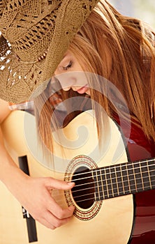 Young woman playing guitar with expression