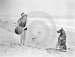 Mujer joven su el perro a esfera sobre el Playa 