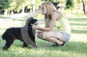 A young woman playing with her dog