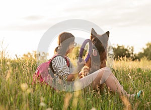 Young woman playing with her German Shepherd dog at the park