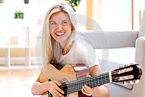 Young woman playing her guitar