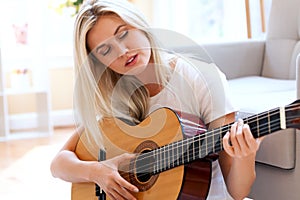 Young woman playing her guitar