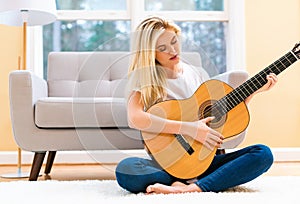 Young woman playing her guitar