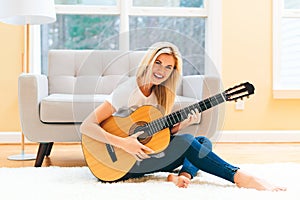 Young woman playing her guitar