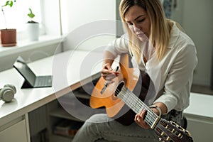Young woman playing her guitar at home. High quality photo