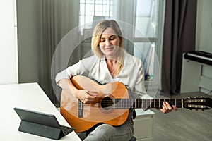 Young woman playing her guitar at home. High quality photo