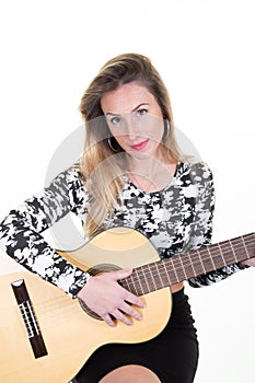 Young woman playing her guitar at home white wall background