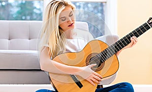 Young woman playing her guitar