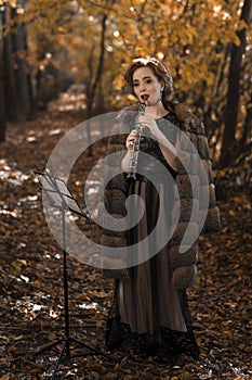 Young woman playing oboe against musical stand