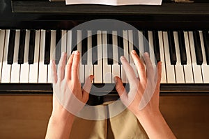 Young woman playing piano, above view. Music lesson