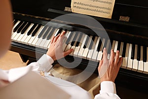 Young woman playing piano, closeup. Music lesson