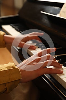 Young woman playing piano, closeup. Music lesson