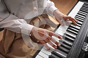 Young woman playing piano, closeup. Music lesson