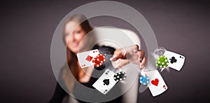 Young woman playing with poker cards and chips