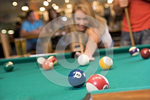 Young woman playing pool in a bar