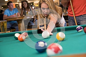 Young woman playing pool in a bar