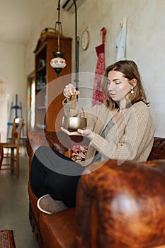 Young woman playing on a singing tibetian bowl.Relaxation and meditation.Sound therapy,alternative medicine.Buddhist