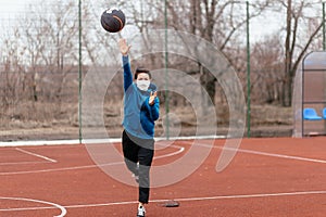 A young woman is playing sports on a sports field in a mask. Protection from coronavirus infection with a medical mask