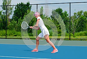 Young woman is playing tennis on the tennis court