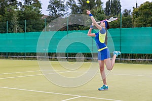 Young woman playing tennis wearing a sportswear serving tennis b