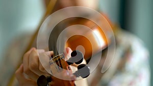 Young woman playing the violin. Hands of musician, close up view