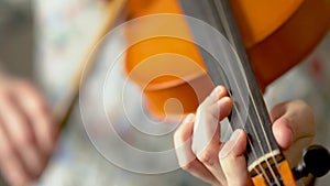 Young woman playing the violin. Hands of musician, close up view. Front view