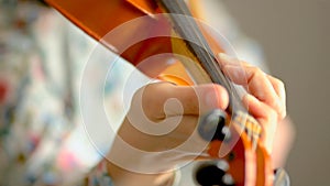 Young woman playing the violin. Hands of musician, close up view. Front view