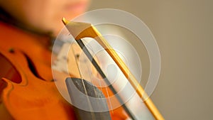 Young woman playing the violin. Hands of musician, close up view. Front view