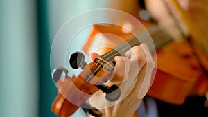 Young woman playing the violin. Hands of musician, close up view. Front view