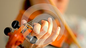 Young woman playing the violin. Hands of musician, close up view. Front view