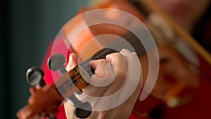 Young woman playing the violin. Hands of musician, close up view. Front view