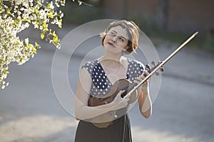 young woman playing violin outdoors