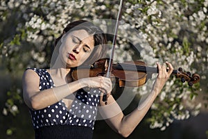 young woman playing violin outdoors