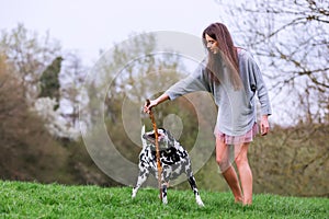 Young woman plays with a Dalmatian dog